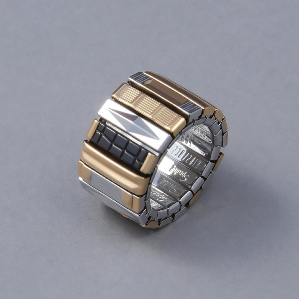 Szeroki pierścionek z pozłacanych ogniw ze stali. LA DEFENSE