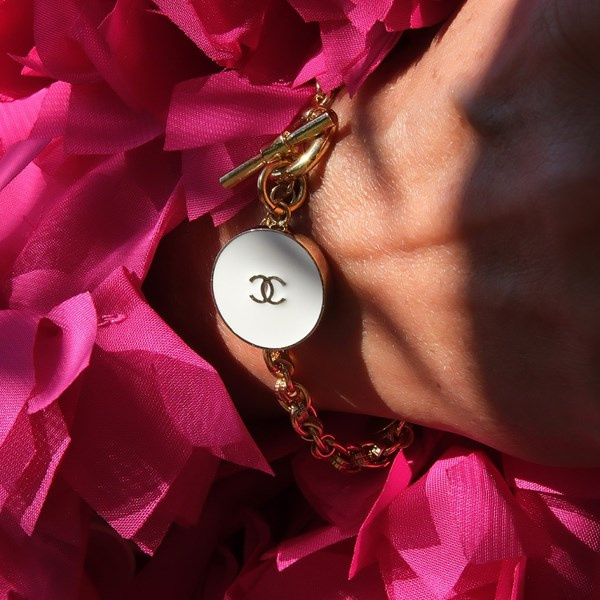 Złocona bransoletka z białym guzikiem i zapięciem toggle. MADAME CHIC