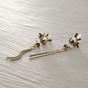 Złocone i srebrzone kolczyki z białymi i czarnymi kryształami. COMETE DE LUMIERE